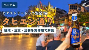 ハノイ・タヒエン通りの路上席でタイガービールを持つ手。提灯が灯る夜の旧市街