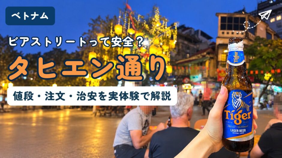 ハノイ・タヒエン通りの路上席でタイガービールを持つ手。提灯が灯る夜の旧市街