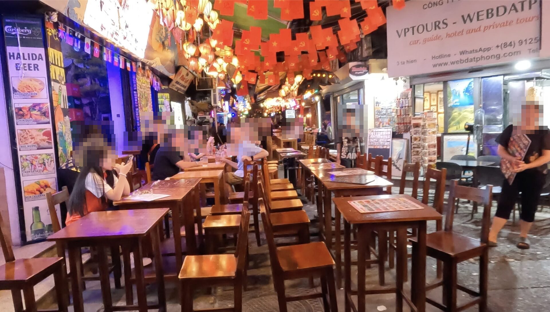 夜のハノイ旧市街タヒエン通り。提灯の下に路上のテーブルとイスが並ぶ
