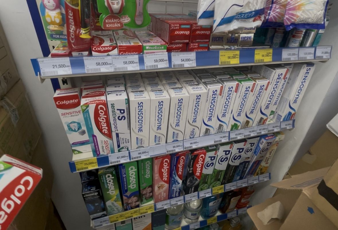 Pharmacityの歯磨き粉売り場。Colgate・Sensodyne・P/Sが並び、ドンの値札が付いている